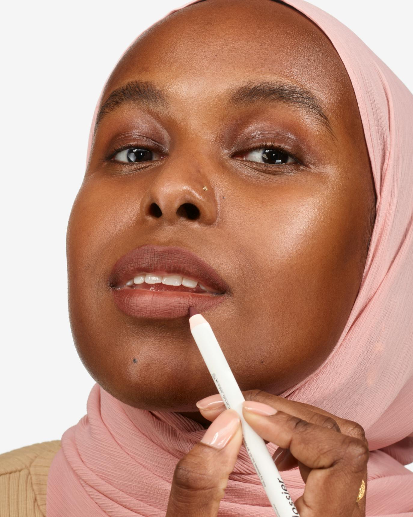 Nasra wears Lip Line in Flush.