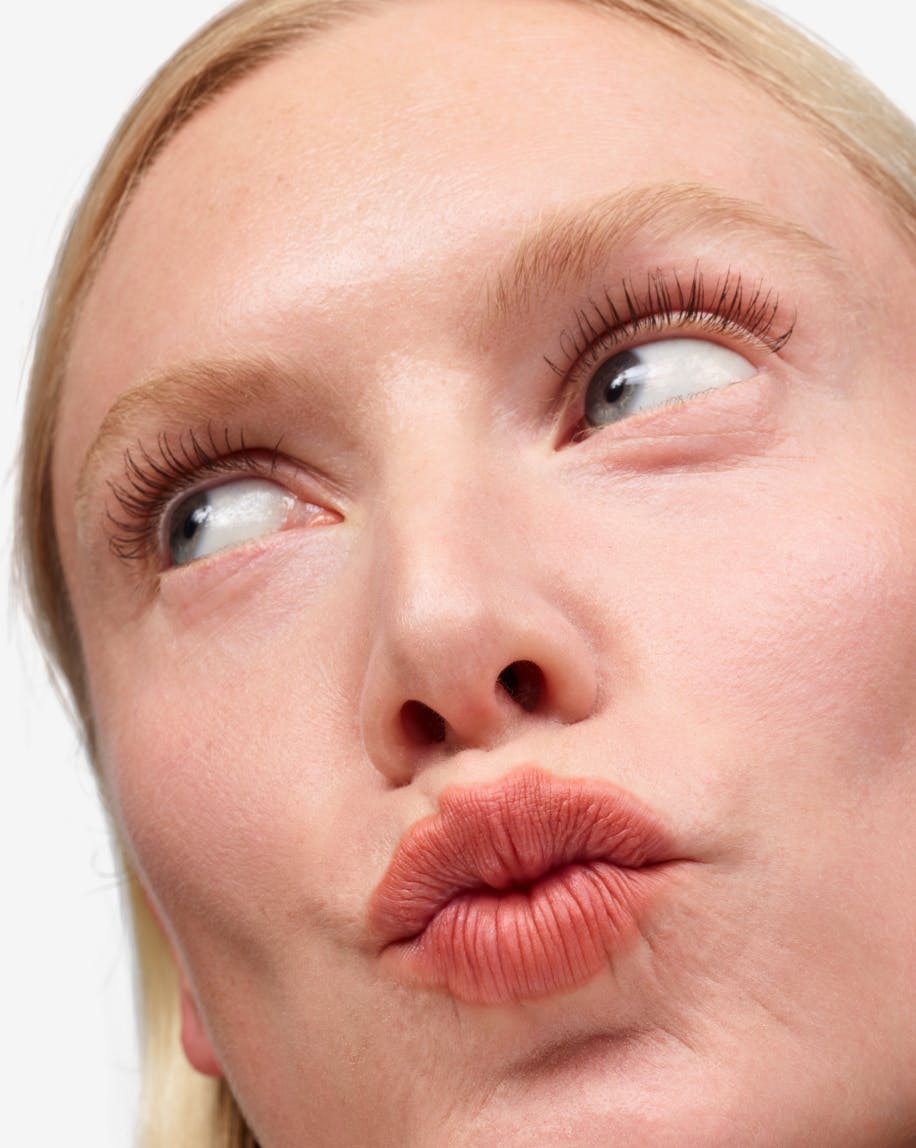 model making a puckered lip face wearing cake
