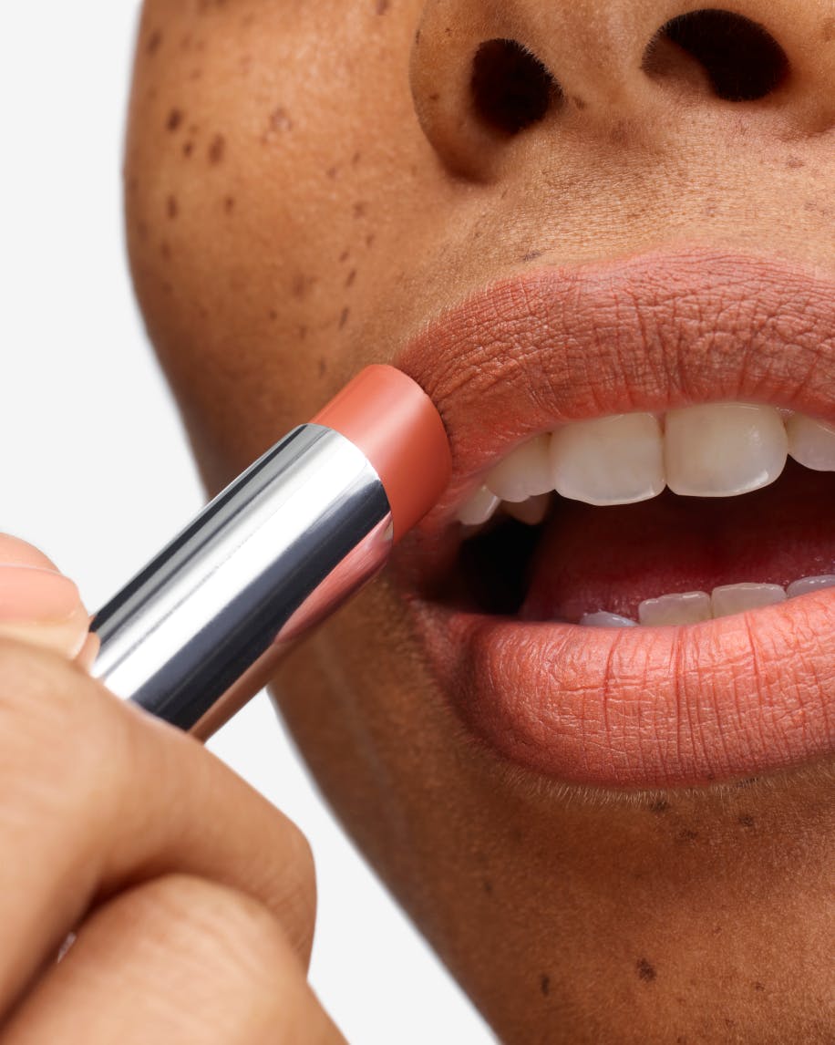 close up of model applying cake to lips
