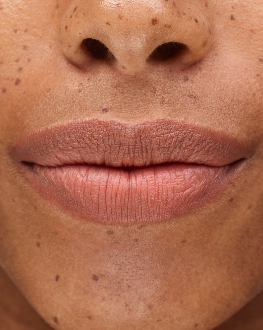 close up of smiling mouth wearing generation g in leo on lips