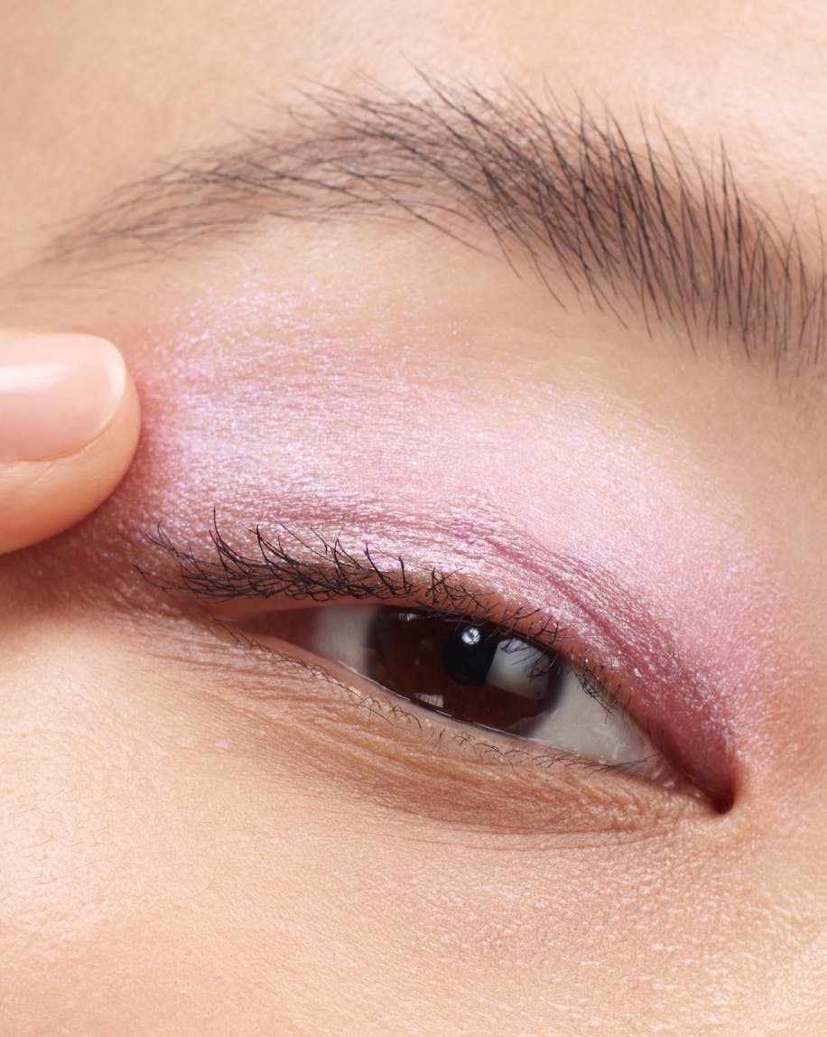 Model applies Lidstar in Lily with finger.