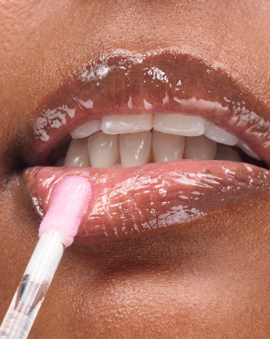 up close shot of model applying clear lipgloss