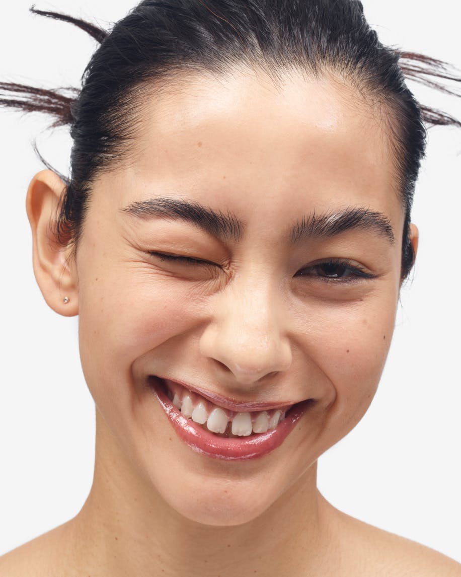 model wears lip gloss in red