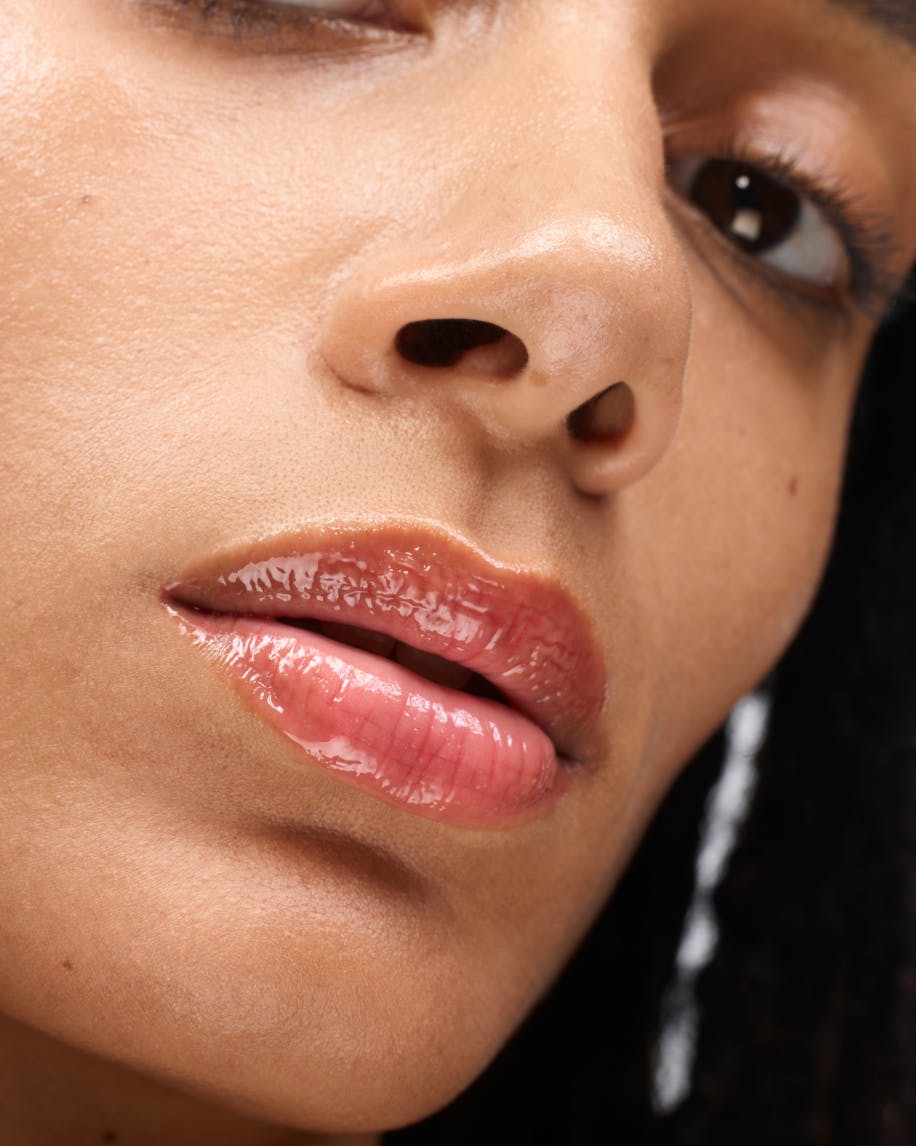 model wears lipgloss in red