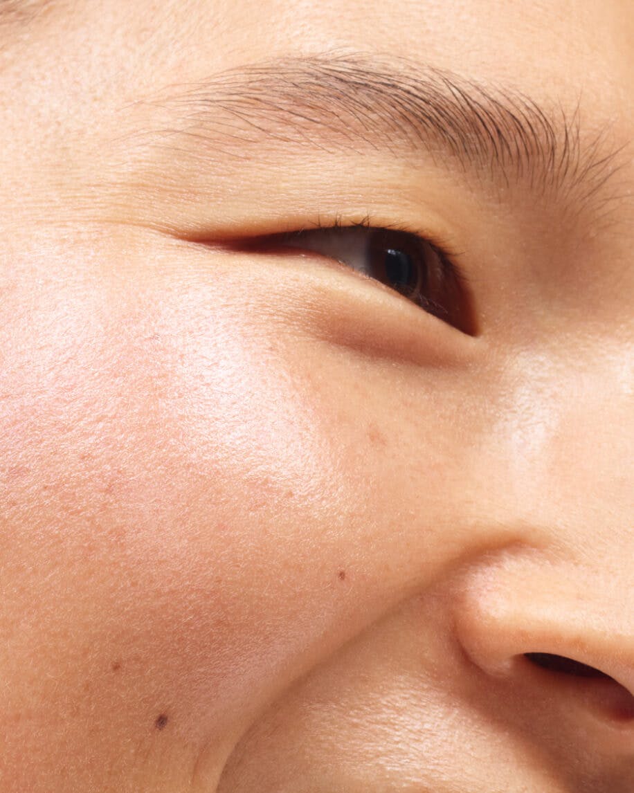 close up of model's cheek wearing haloscope in moonstone